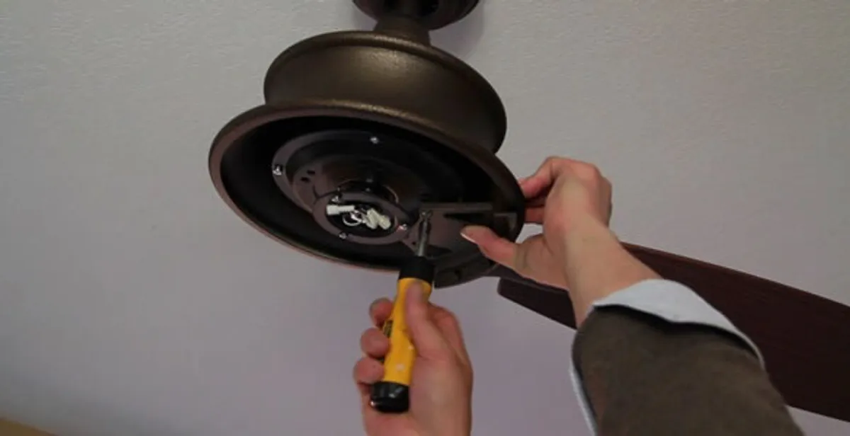 Electrician installing ceiling fan mounting bracket and fixture in Boise, ID