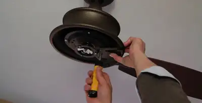 Electrician installing ceiling fan mounting bracket and fixture in Boise, ID