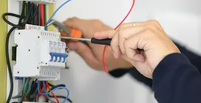 Electrician installing and adjusting circuit breakers in an electrical panel in Boise, ID