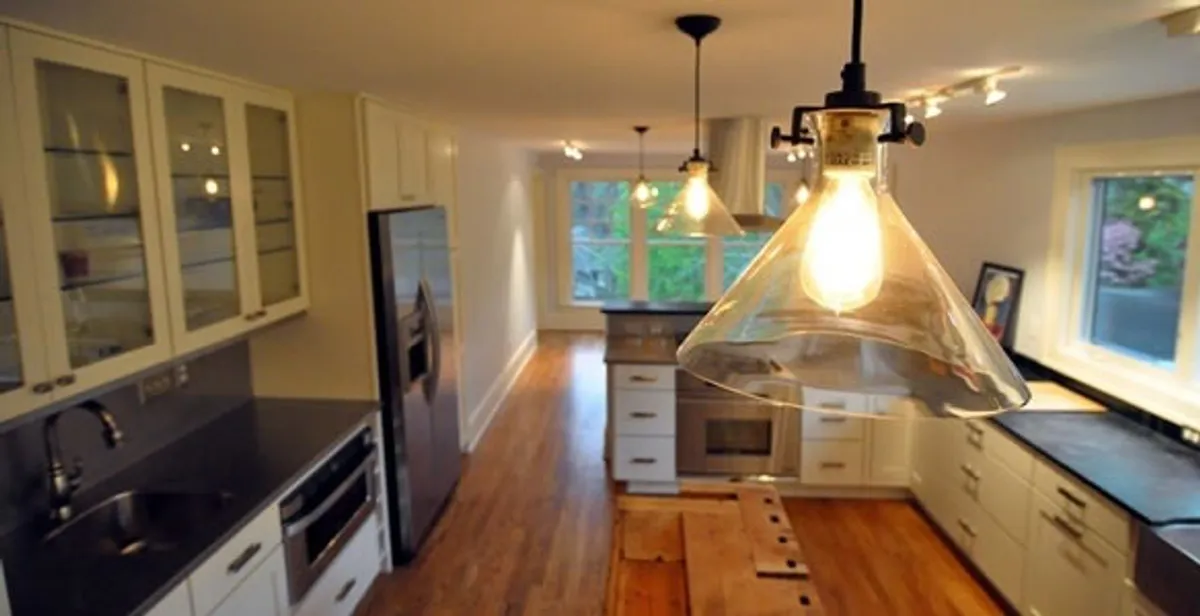 Residential electrician installing modern indoor light fixture in a home in Boise, ID