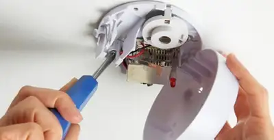 Certified technician wiring smoke detector during installation in Boise, ID